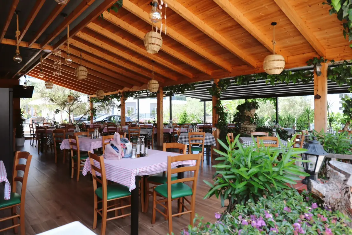 Inside Afrimi — warm wood tables and olive green chairs
