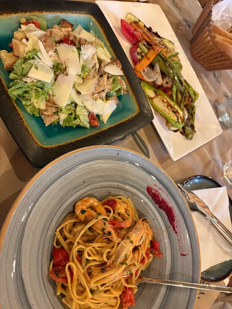 Caesar salad, grilled vegetables and seafood linguine
